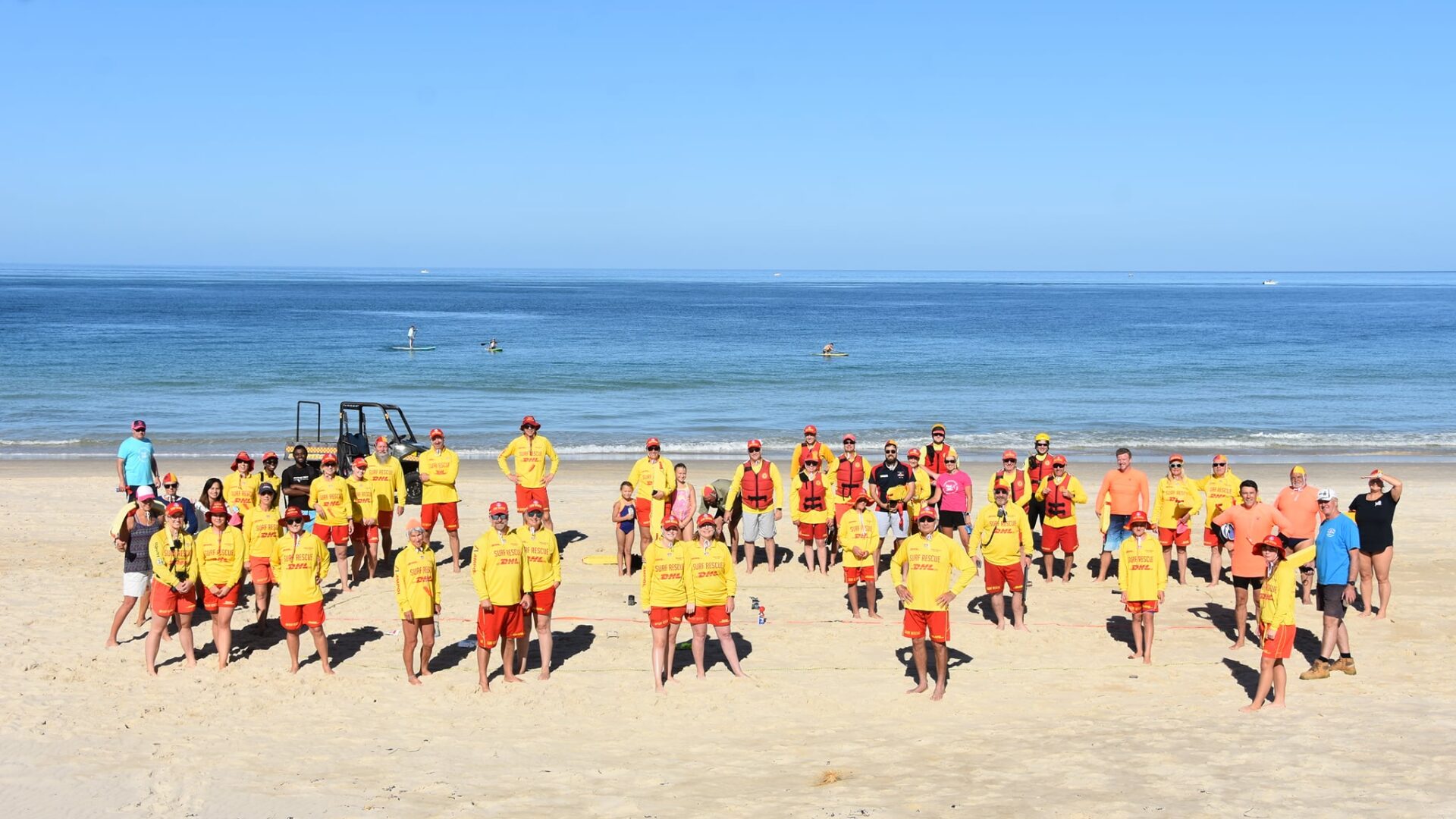 Group of surf lifesavers standing on the beach at West Beach SLSC during a morning patrol session.